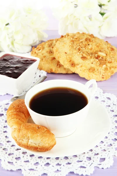 Tasty croissants and cup of coffee on table close-up — Stock Photo, Image