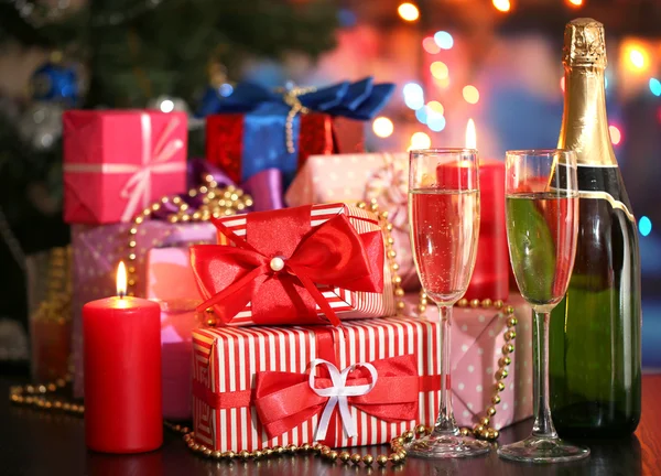 Many gifts and glasses of champagne on bright background — Stock Photo, Image