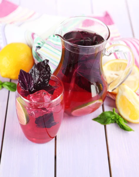 Rode basilicum limonade in kruik en glas, op houten achtergrond — Stockfoto