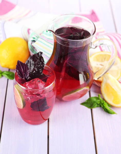 Limonada de albahaca roja en jarra y vidrio, sobre fondo de madera —  Fotos de Stock