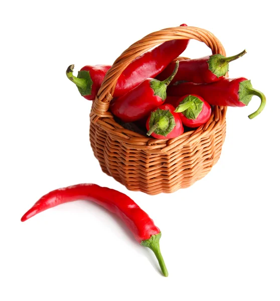 Pimientos rojos picantes en canasta de mimbre, sobre tela de saco, aislados sobre blanco — Foto de Stock