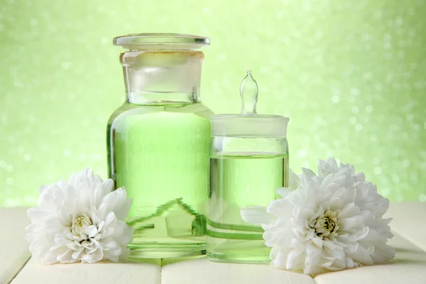 Yeşil zemin üzerine ahşap masa üzerinde renk özü ile cam şişe — Stok fotoğraf