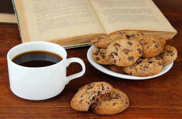 Xícara de café com biscoitos e livros sobre fundo de madeira — Fotografia de Stock