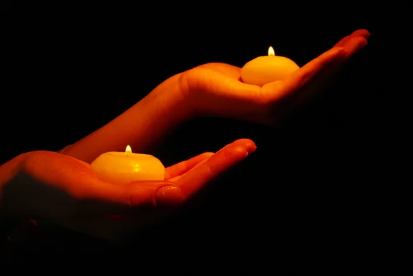 Queimando velas em mãos isoladas em preto — Fotografia de Stock