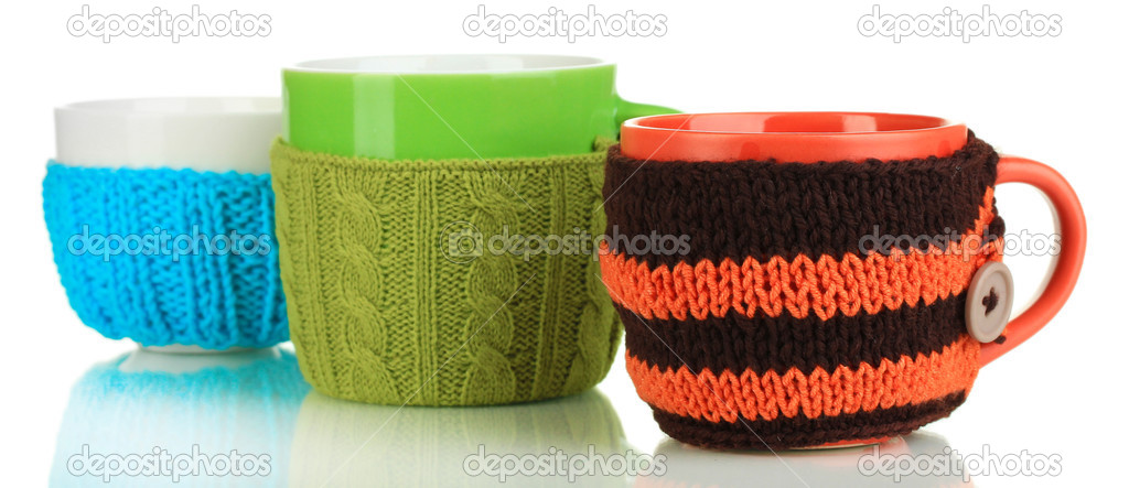 Cups with knitted things on it isolated on white