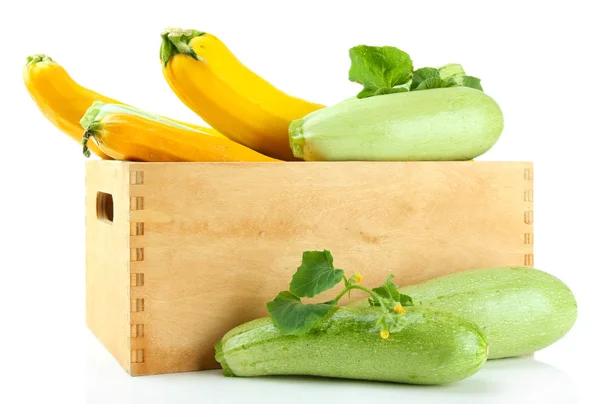Rohe gelbe und grüne Zucchini in Holzkiste, isoliert auf weiß — Stockfoto