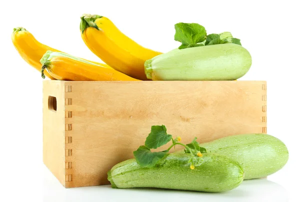 Ruwe gele en groene courgette in houten kist, geïsoleerd op wit — Stockfoto