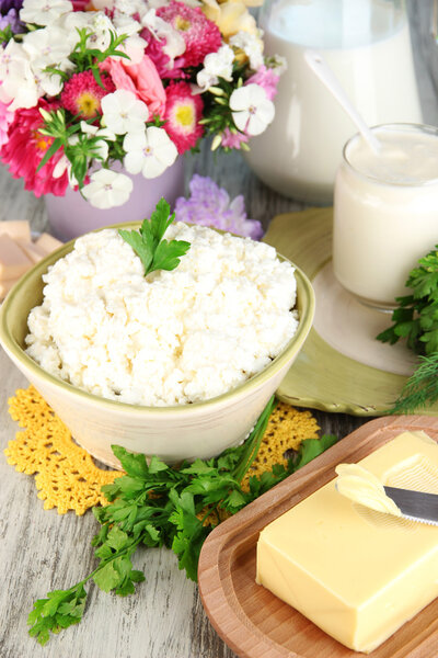 Fresh cottage cheese with greens on wooden table close-up