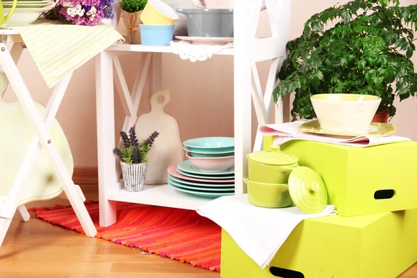 Mobília branca bonita com utensílios de mesa e decoração, no fundo da parede de cor — Fotografia de Stock