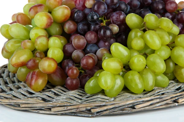 Raisin frais sur tapis d'osier isolé sur blanc — Photo