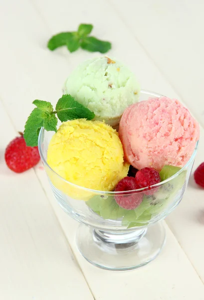 Tasty ice cream scoops, on wooden table — Stock Photo, Image