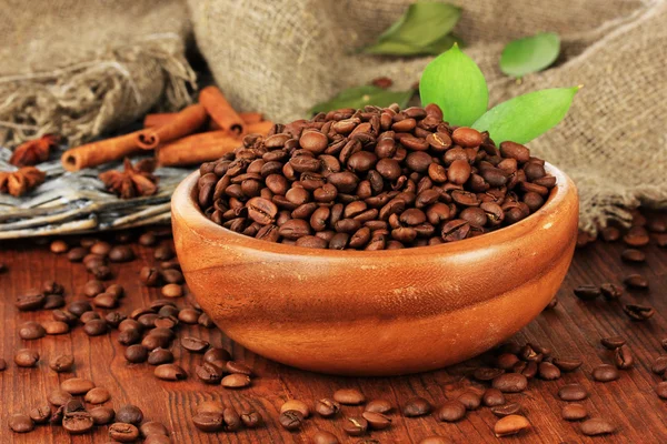 Koffie bonen in kom op houten achtergrond — Stockfoto