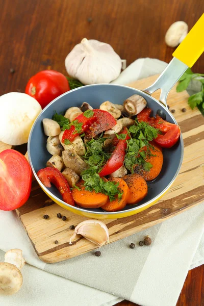 Légumes frais tranchés dans une poêle sur une table en bois close-up — Photo