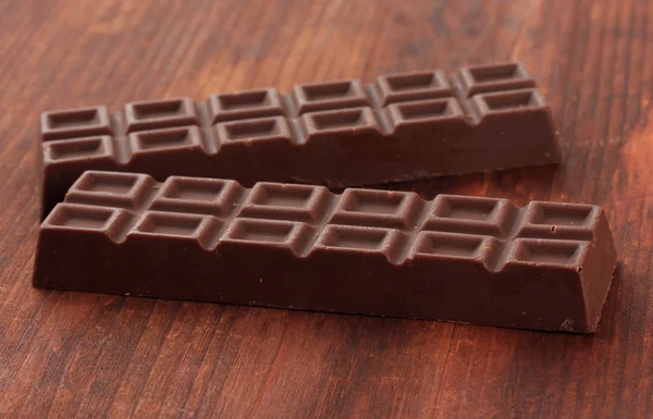 Deux délicieuses barres de chocolat sur fond en bois — Photo