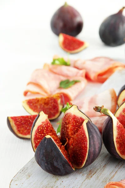 Figues savoureuses avec jambon sur table en bois blanc — Photo