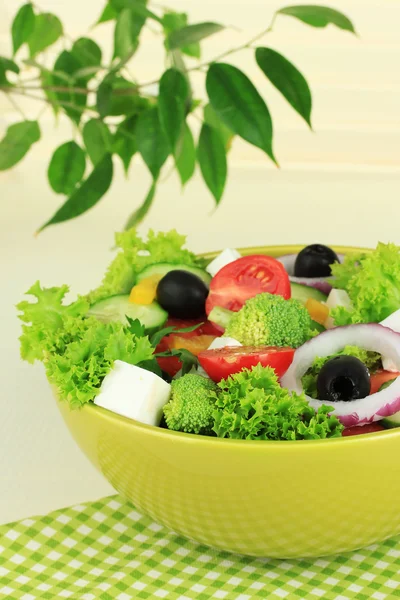 Griechischer Salat auf Teller auf Tisch auf hellem Hintergrund — Stockfoto