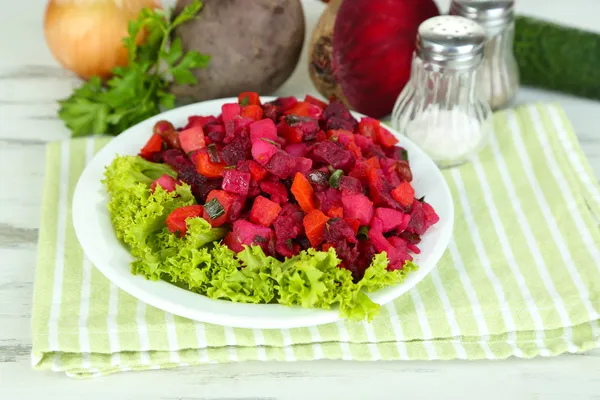 Rödbetor sallad på plattan på servett på träbord — Stockfoto