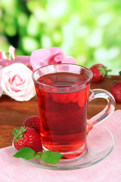 Délicieux thé à la fraise sur table sur fond lumineux — Photo