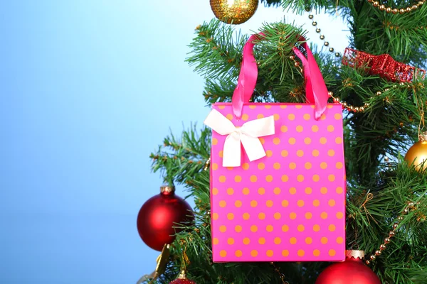 Regalo en el árbol de Navidad sobre fondo de color — Foto de Stock