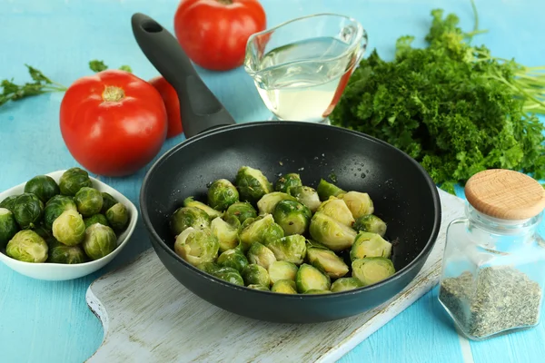 Frische Rosenkohl-Sprossen in Pfanne mit Gemüse und Gewürzen auf Holztisch in Großaufnahme — Stockfoto