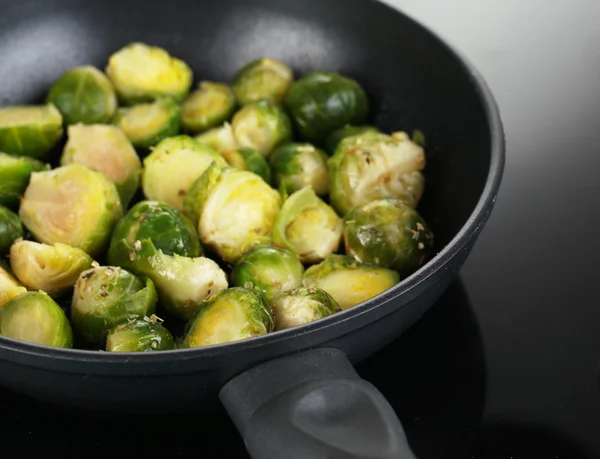 Choux de Bruxelles frais dans une casserole sur la surface de cuisson close-up — Photo