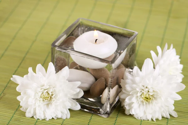 Jarrón decorativo con vela, agua y piedras sobre mesa de madera — Foto de Stock