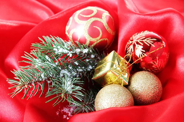 Beautiful Christmas decor on red satin cloth — Stock Photo, Image