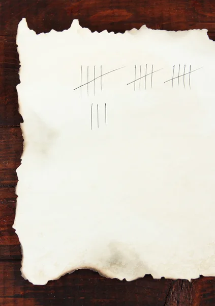 Counting days by drawing sticks on paper on wooden background — Stock Photo, Image