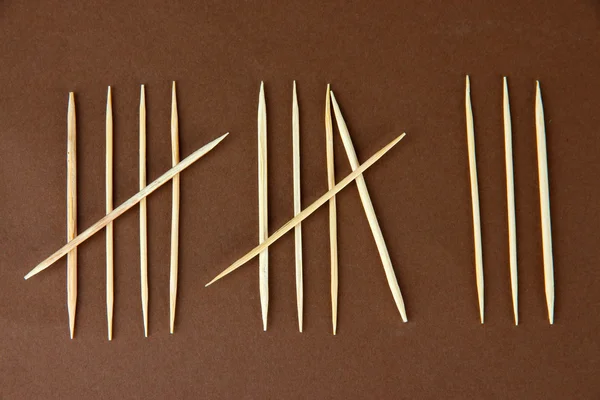 Toothpicks - counting days concept on brown background — Stock Photo, Image