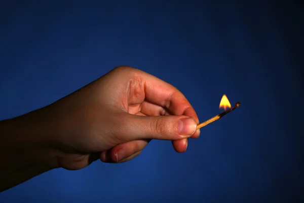 Burning match in hand on black background — Stock Photo, Image