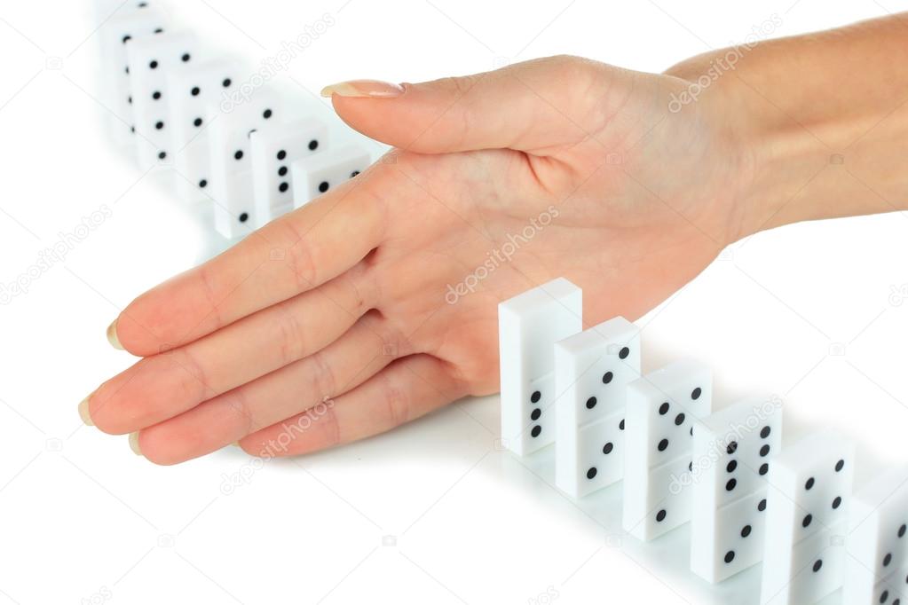 Hand stopping dominoes falling isolated on white
