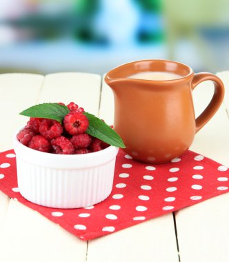 taze Ahududu ve sürahi parlak zemin üzerine ahşap masa üzerinde krem