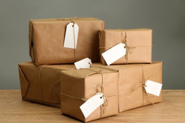kutuları gri arka plan üzerinde ahşap masa hakkında kraft kağıt paketler