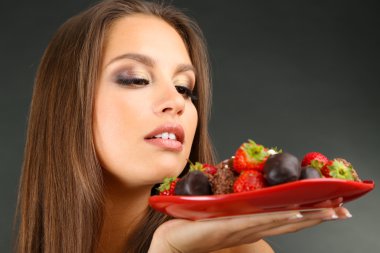 çikolatalı tatlılar plaka gri arka plan üzerine ile güzel genç kız portresi