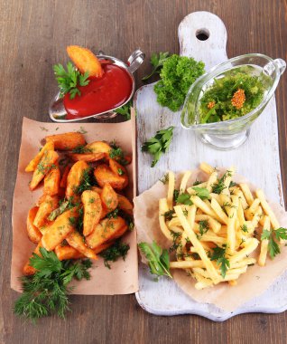 patates kızartması ve ev patateslerin üzerine ahşap masa üzerinde kurulu aydınger kağıdı