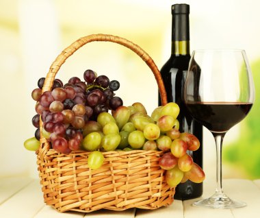 hasır sepet, şişe ve kadeh şarap, açık renkli üzerinde olgunlaşmış üzümler