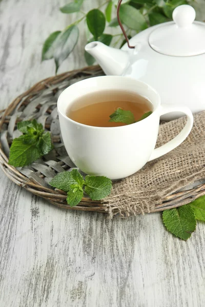 Teapot and cup of herbal tea with fresh mint on wooden table — Stock Photo, Image