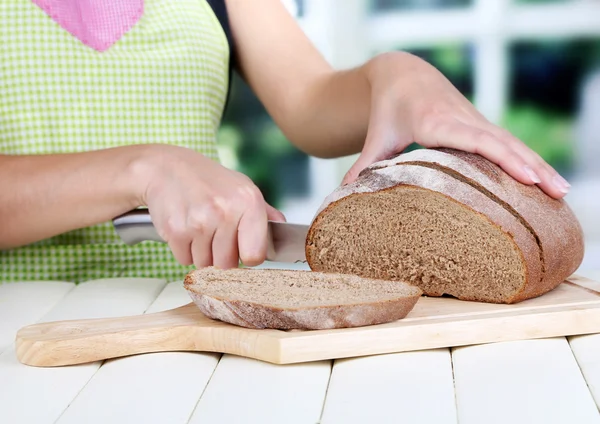 Brot schneiden auf Holzbrett auf Holztisch auf Fensterhintergrund — Stockfoto