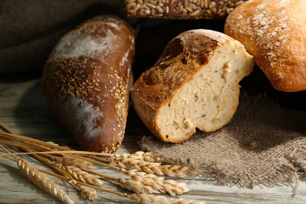 Much bread on sackcloth on wooden board — Stock Photo, Image