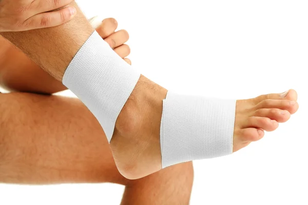 Ung man med elastiska bandage på benet, isolerad på vit — Stockfoto