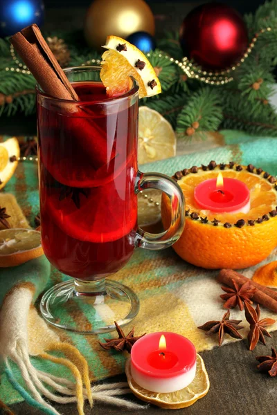 Vin chaud parfumé en verre avec des épices et des oranges autour de la table en bois — Photo