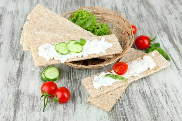 Välsmakande torrt bröd med grönsaker på trä bakgrund — Stockfoto