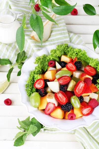 Fruit salad in plate on wooden table — Stock Photo, Image