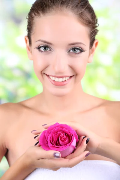 Schönes Mädchen mit Rose auf natürlichem Hintergrund — Stockfoto