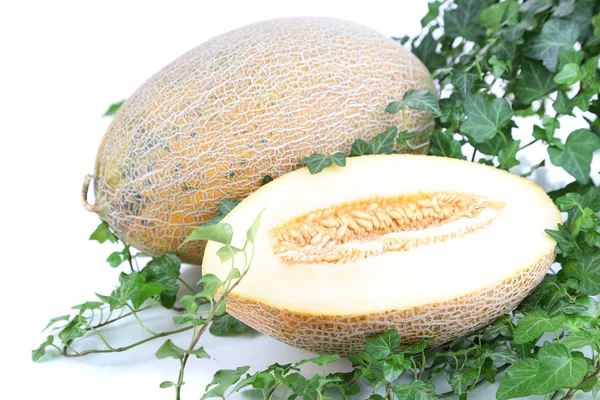 Melones maduros en hojas aisladas sobre blanco —  Fotos de Stock