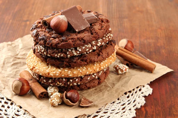 Biscoitos caseiros com sementes de gergelim, chocolate, no guardanapo, no fundo de madeira — Fotografia de Stock