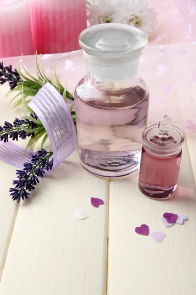 Bouteille en verre avec essence de couleur, sur fond en bois — Photo