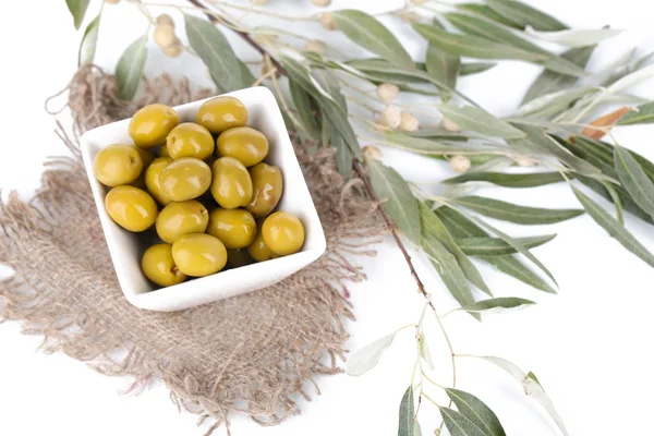 Olive in ciotola con ramo su sacco da vicino — Foto Stock