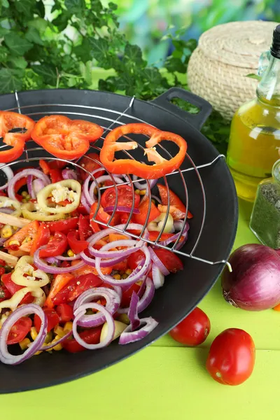 Verdure in wok su tavolo di legno su sfondo naturale — Foto Stock