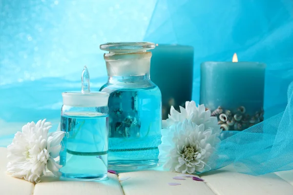 Glass bottles with color essence, on wooden table, on blue background — Stock Photo, Image